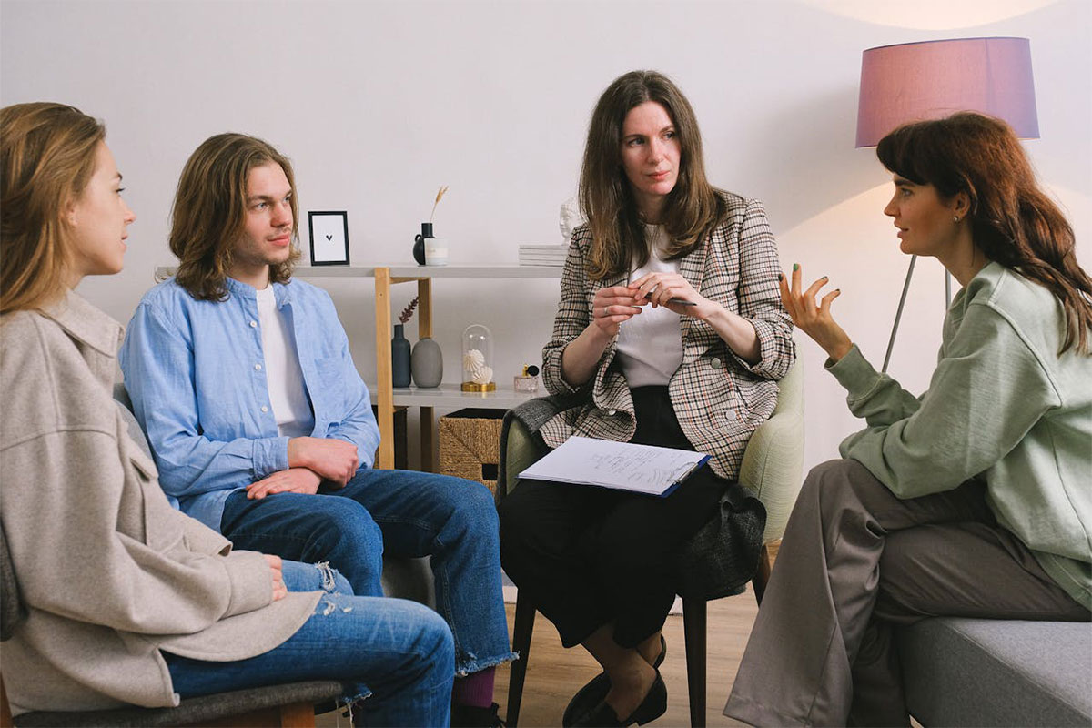 Four people sit together having a conversation