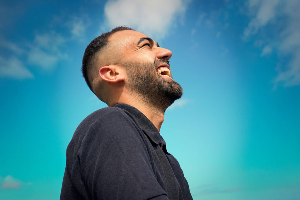 A man looks to the sky, smiling