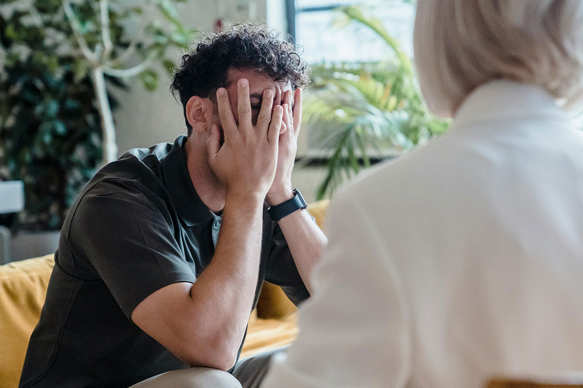 A man sits with his head in his hands